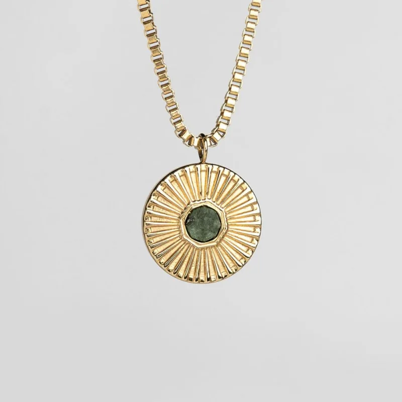 Goldene Halskette mit rundem Anhänger und grünem Stein