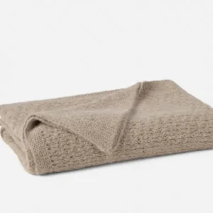 Coyuchi Alpamayo Suri Alpaca Knit throw in taupe, folded to show open-weave texture.