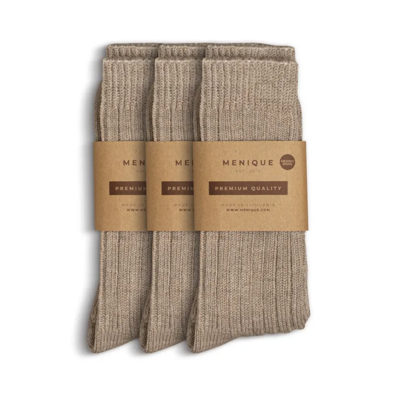 Three pairs of women’s beige ribbed thick socks, neatly folded with Menique brown paper packaging labeled ‘Premium Quality – Merino Wool.