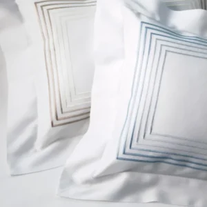 Dea Milano white cotton fitted sheet with geometric embroidered border detail.