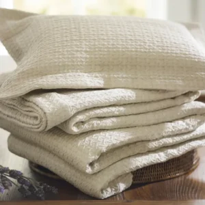 SDH Purists Kimi ivory woven cotton fabric sample stack with pillow sham on wooden tray.