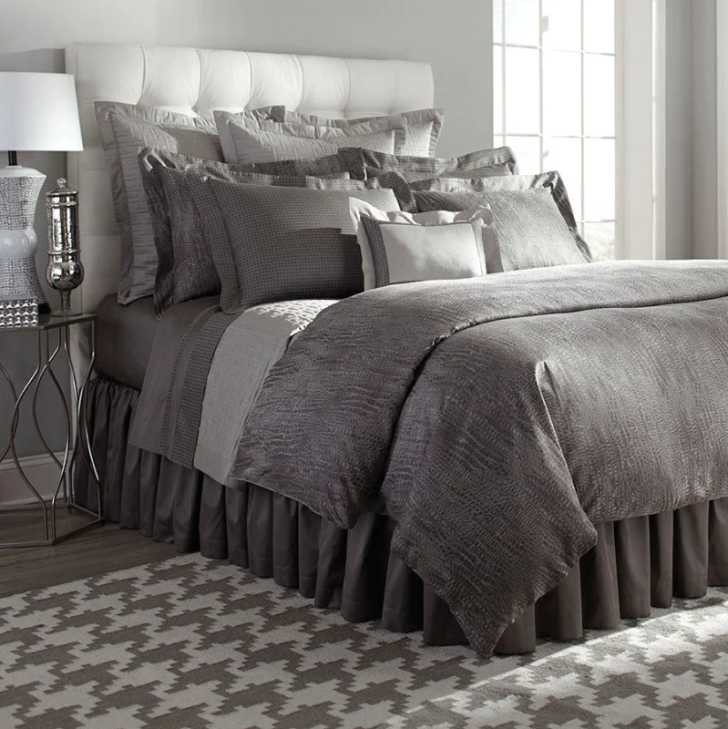 Home Treasures Roberto quilted coverlet in charcoal with layered silver euro shams on styled bed.